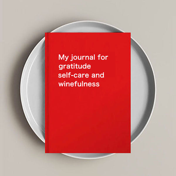 A Journal Notebook with the words 'GRATITUDE SELF-CARE AND WINEFULNESS' printed on the cover