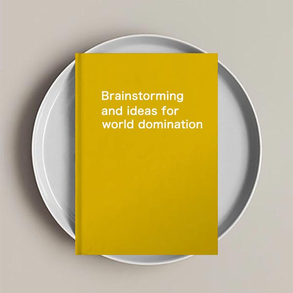 A journal notebook with the text'BrainStorming and Ideas for World Domination' on the cover