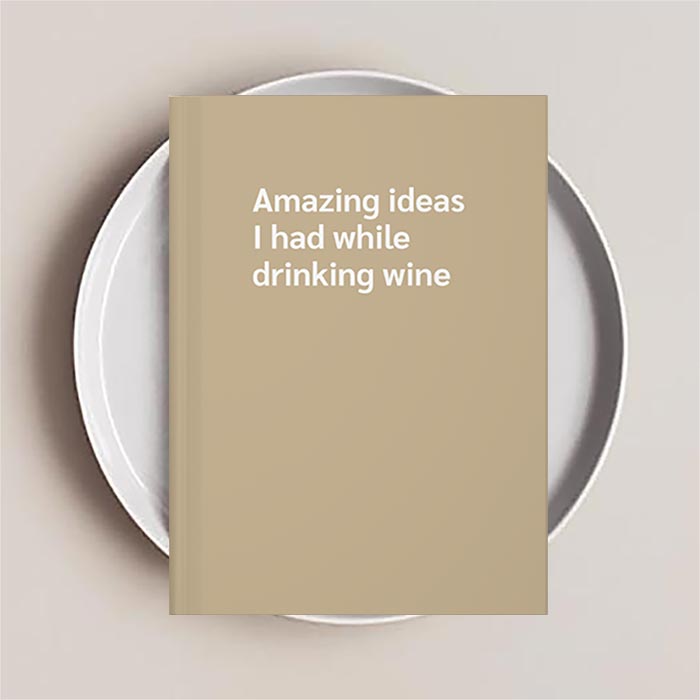 Journal notebook with the text 'Amazing ideas I had while drinking wine' on the cover