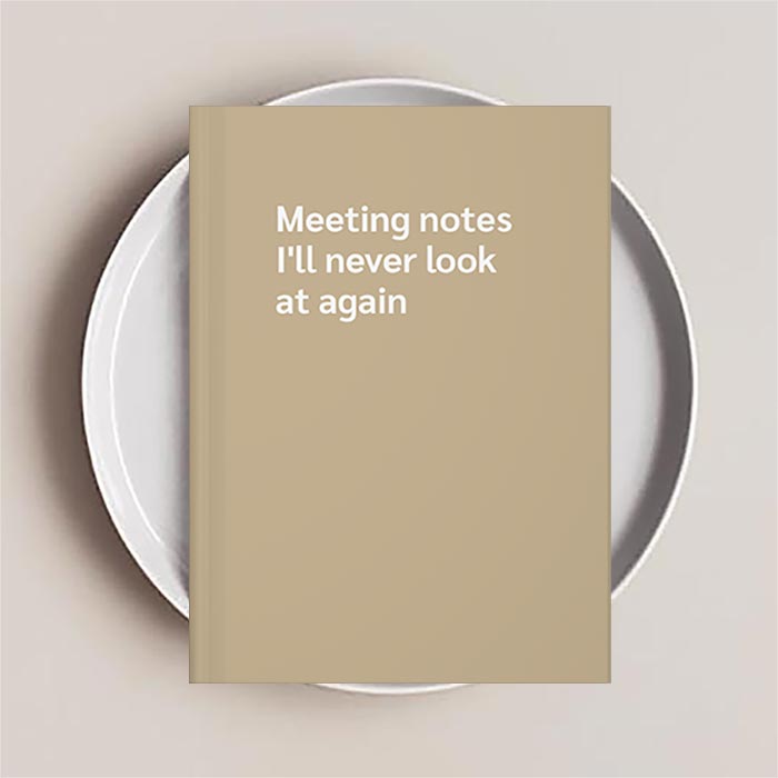 Journal notebook with 'Meeting notes I'll never look at again' text on the cover
